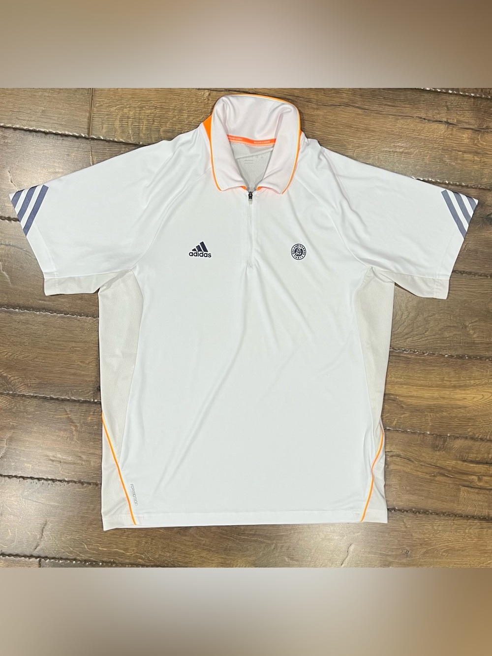 Adidas Roland Garros Men’s White Polo with blue and orange accents and trim. LGE